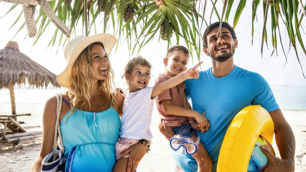 Rodzina stoi na plaży pod palmami podczas wakacji