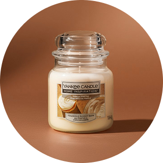 Świeca zapachowa Yankee Candle w szklanym słoiku na ciepłym, brązowym tle.